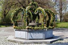 Osterkrone über dem Dorfbrunnen am Kirchenplatz Bruckmühl