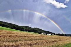 Regenbogen über Ortschaft Laah